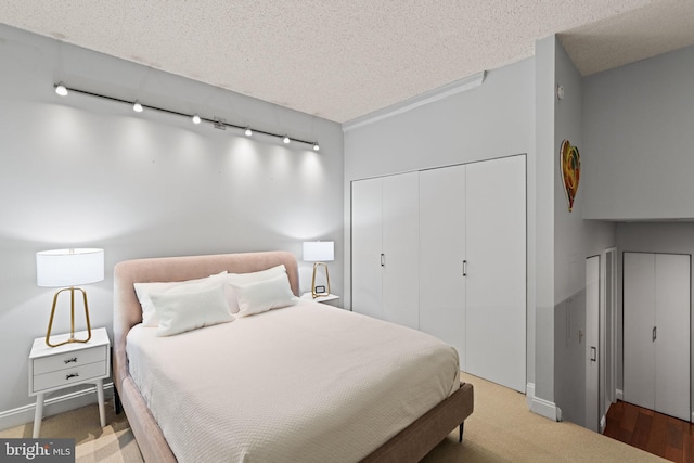 bedroom featuring a closet, a textured ceiling, and track lighting