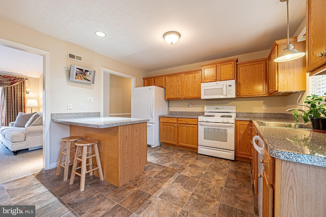 kitchen with white appliances, visible vents, a kitchen breakfast bar, a peninsula, and a sink