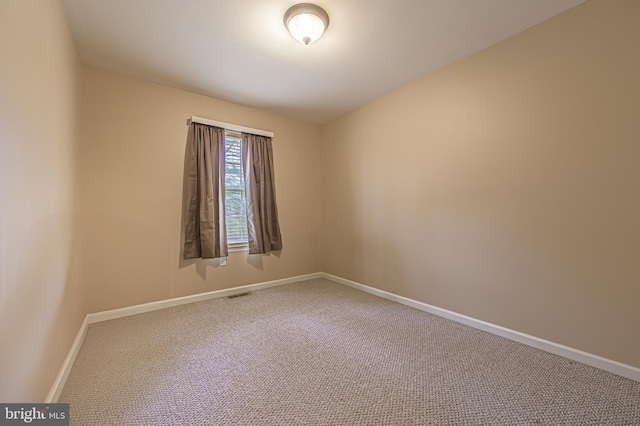 unfurnished room with carpet flooring, visible vents, and baseboards