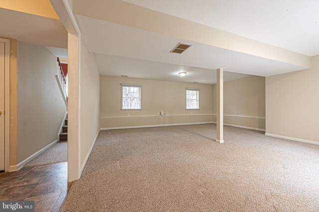 below grade area with carpet floors, stairway, baseboards, and visible vents