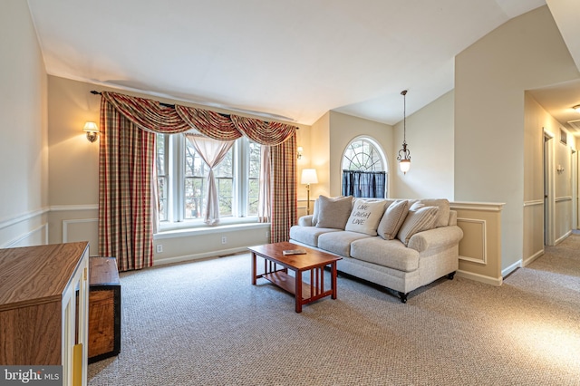 carpeted living room with lofted ceiling and baseboards