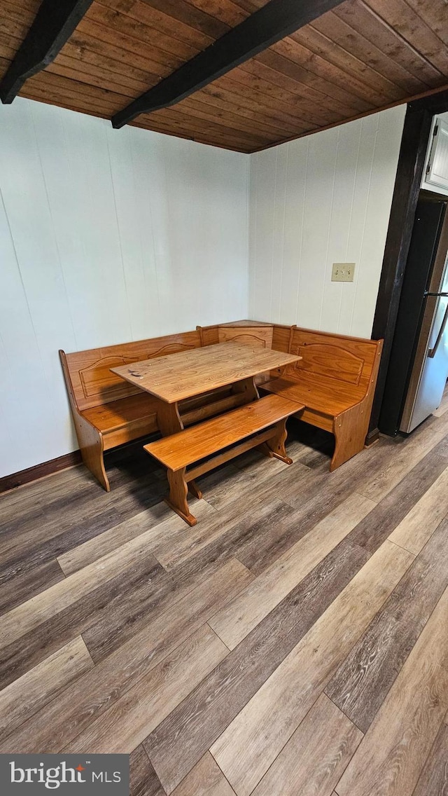 dining room with wooden ceiling, beamed ceiling, and wood finished floors