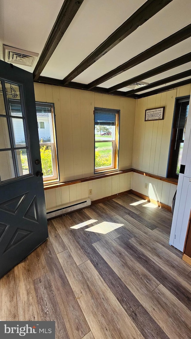 interior space featuring baseboards, beamed ceiling, baseboard heating, and wood finished floors