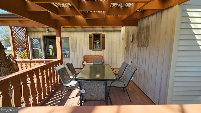 wooden terrace with outdoor dining space and a pergola