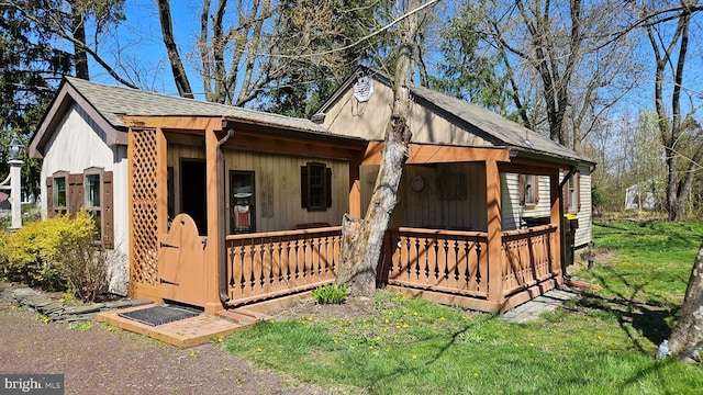 view of home's exterior featuring a porch and a shingled roof