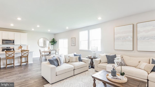 living room featuring baseboards, light wood-style floors, and recessed lighting