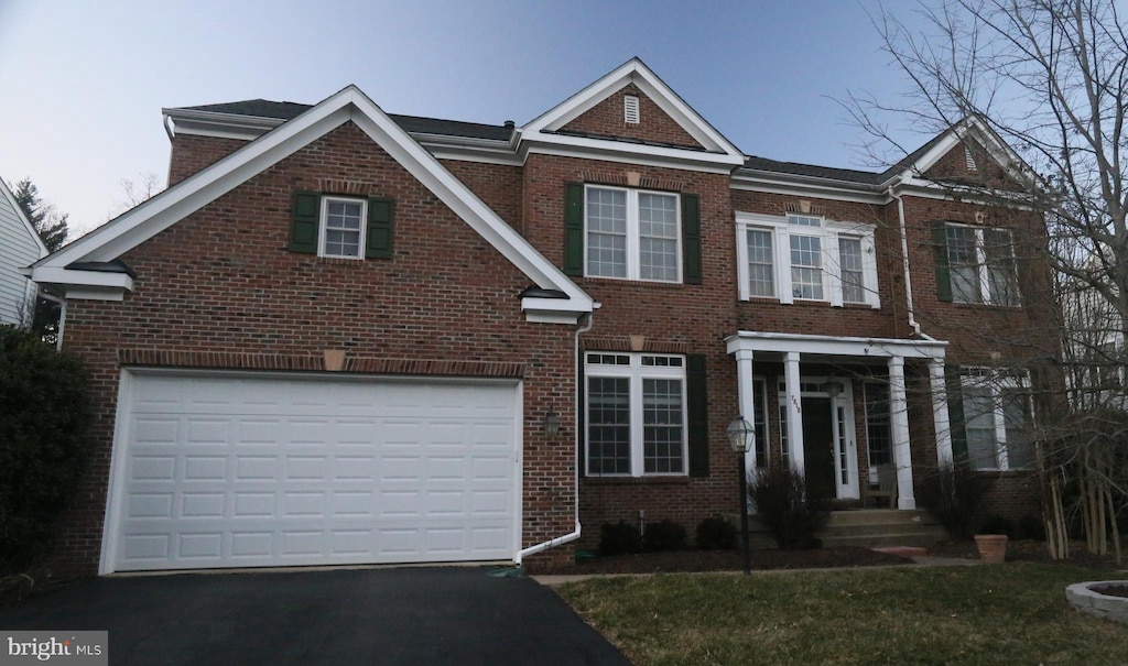 view of front of property with an attached garage, driveway, and brick siding