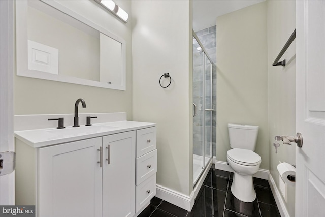 full bath featuring a stall shower, vanity, toilet, and baseboards