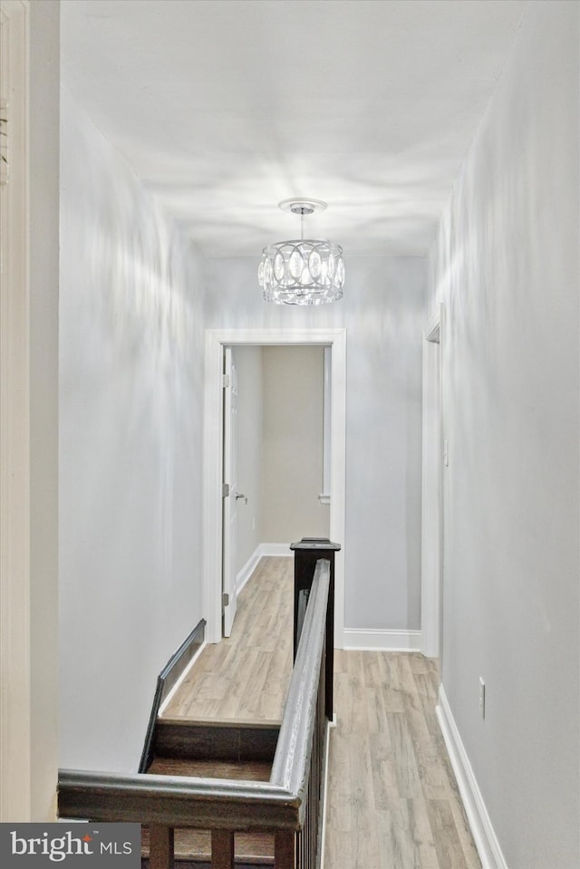 hall with light wood-type flooring and baseboards