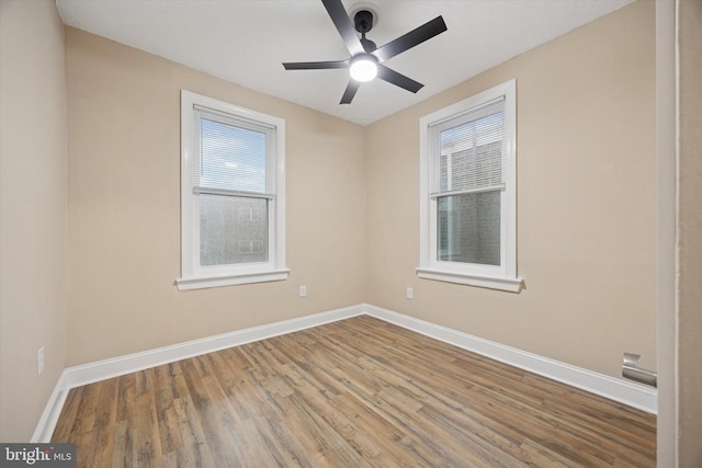 spare room with a ceiling fan, baseboards, and wood finished floors