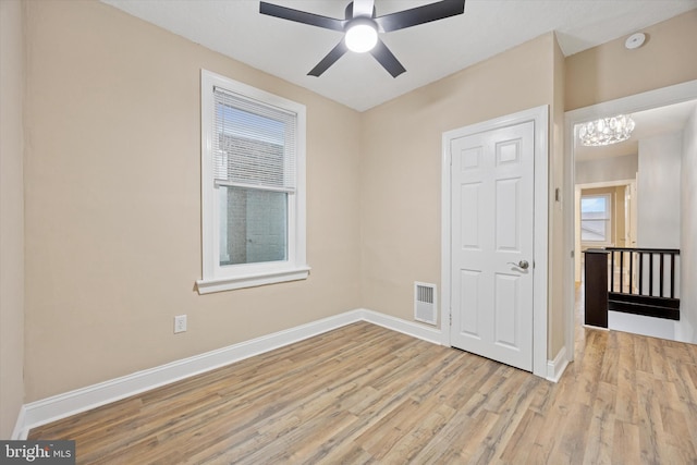 spare room with ceiling fan, wood finished floors, visible vents, and baseboards