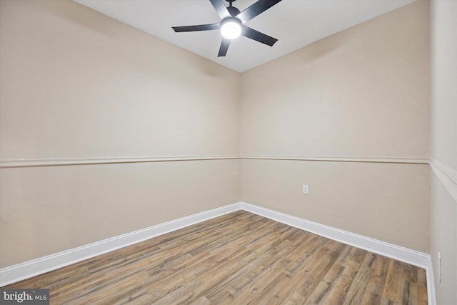 empty room featuring ceiling fan, baseboards, and wood finished floors