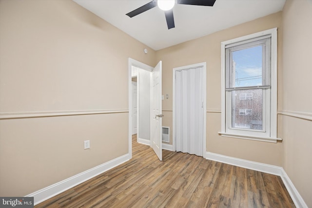 unfurnished bedroom with visible vents, wood finished floors, a ceiling fan, and baseboards