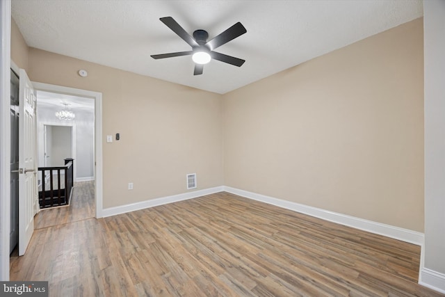 unfurnished room featuring light wood finished floors, baseboards, visible vents, and a ceiling fan