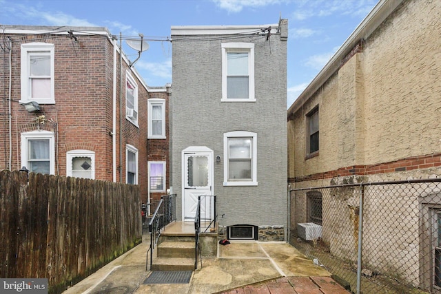 back of property featuring brick siding, cooling unit, and fence