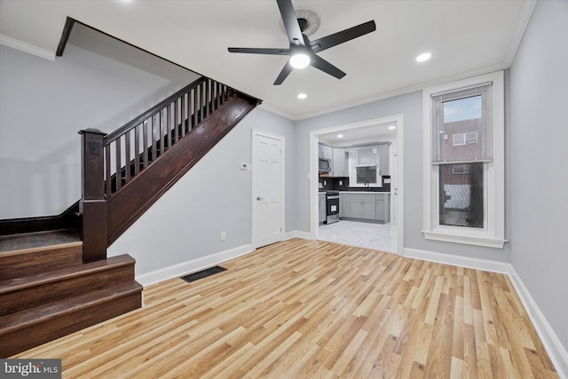 unfurnished living room with visible vents, light wood finished floors, and stairs