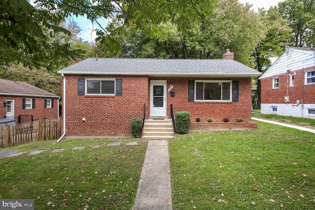 bungalow with brick siding, a chimney, a front yard, entry steps, and fence