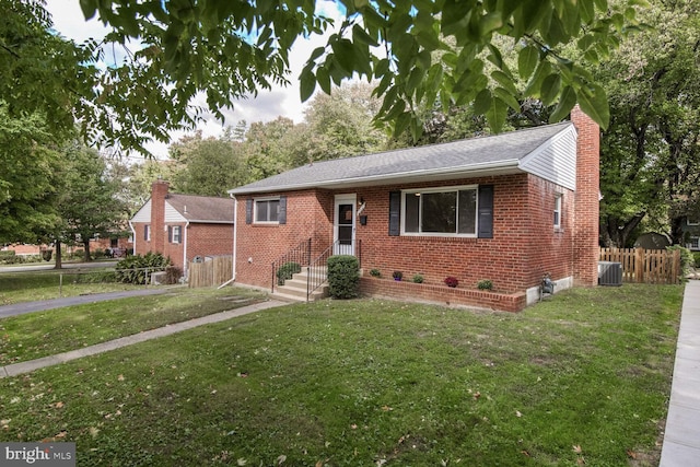 view of front of home featuring a front yard, a chimney, fence, and brick siding