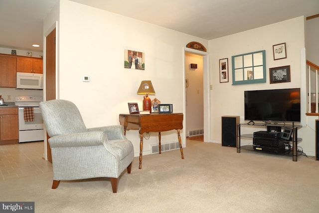 sitting room with recessed lighting, stairs, visible vents, and light colored carpet