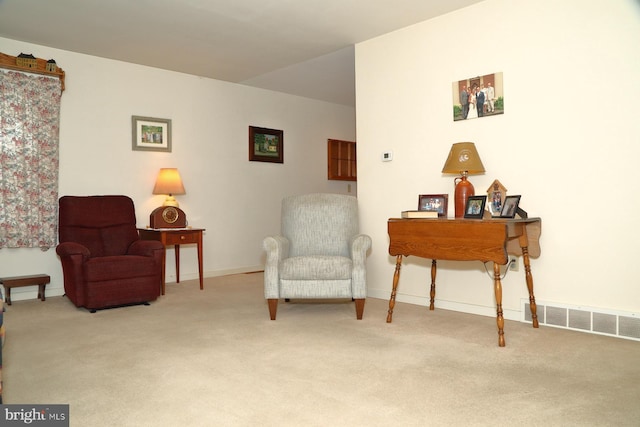 living area featuring carpet floors, visible vents, and baseboards