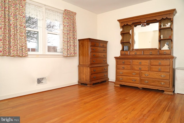 unfurnished bedroom featuring visible vents, baseboards, and wood finished floors