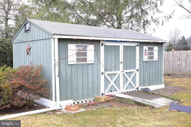 view of shed featuring fence