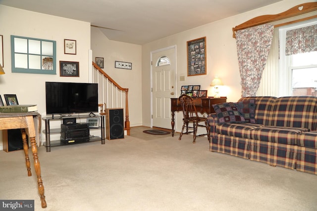 carpeted living area with stairs