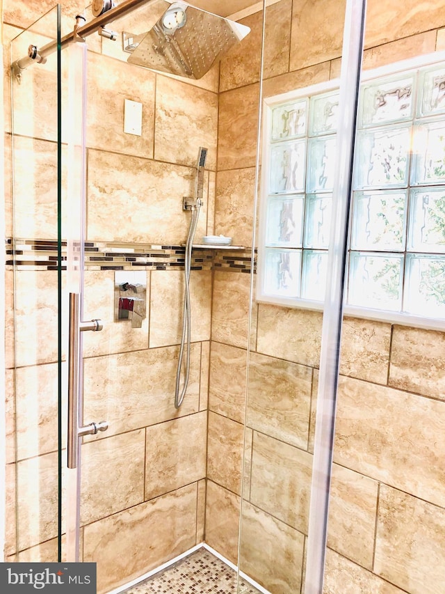 full bathroom with a shower stall and a ceiling fan