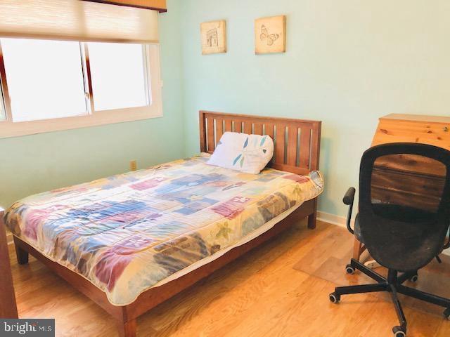 bedroom featuring wood finished floors and baseboards