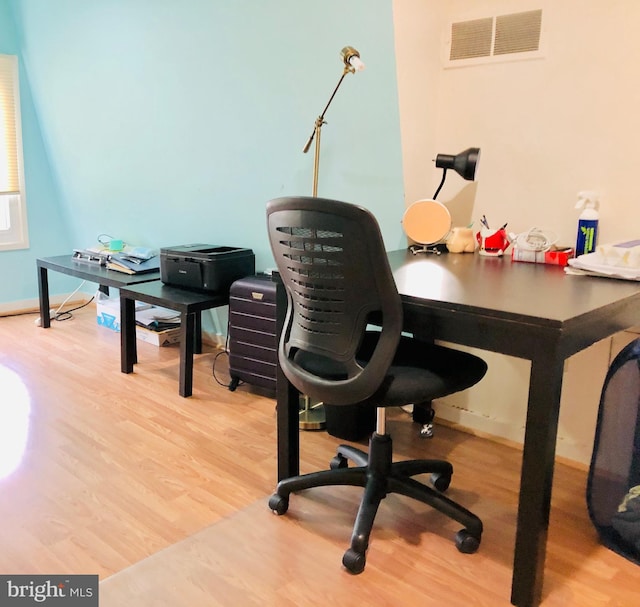 home office featuring visible vents, baseboards, and wood finished floors