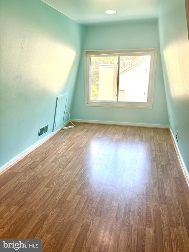 additional living space with visible vents, baseboards, and wood finished floors