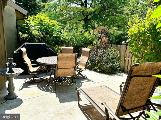 view of patio featuring outdoor dining area and fence