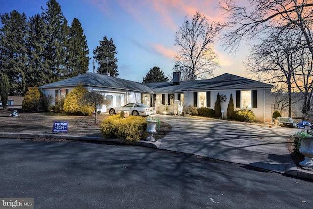 view of front of home featuring driveway and a chimney