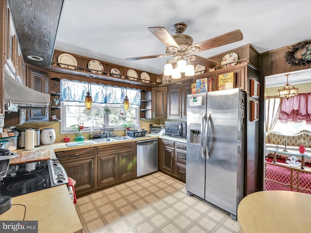 kitchen with light floors, a sink, light countertops, appliances with stainless steel finishes, and open shelves