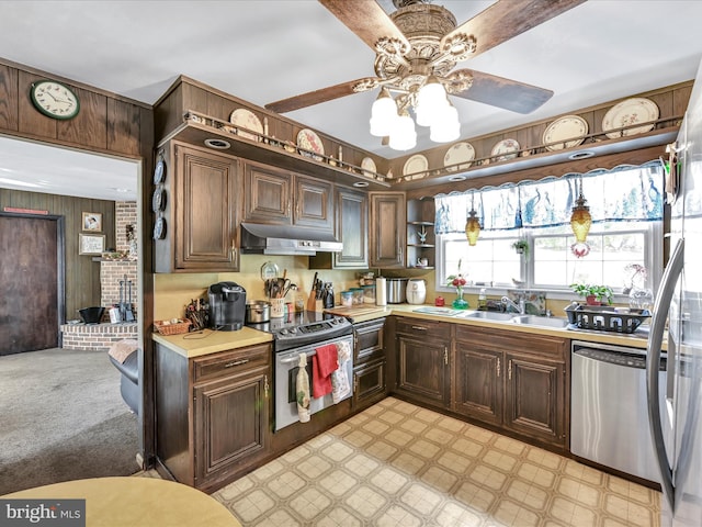 kitchen with stainless steel appliances, light countertops, a sink, and under cabinet range hood