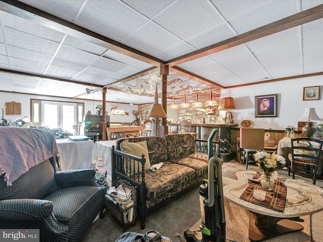 living area featuring french doors, a drop ceiling, and carpet flooring