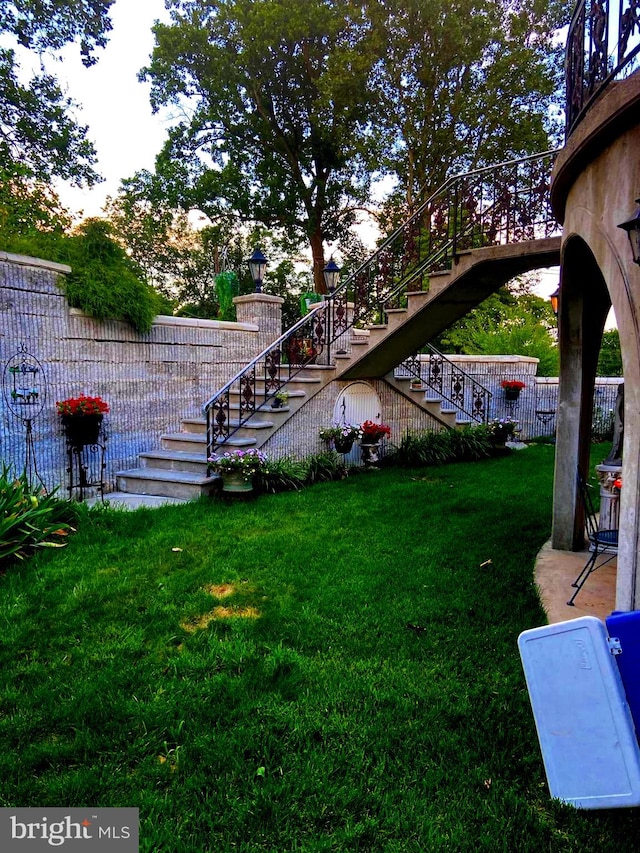 view of yard featuring fence and stairway