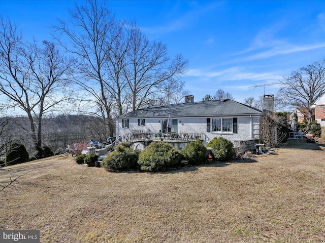 back of property with a yard, stairway, and a chimney