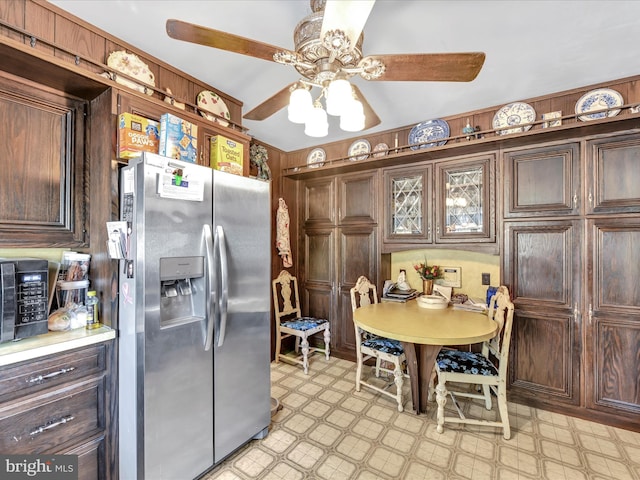 kitchen with a ceiling fan, light countertops, dark brown cabinets, light floors, and stainless steel refrigerator with ice dispenser