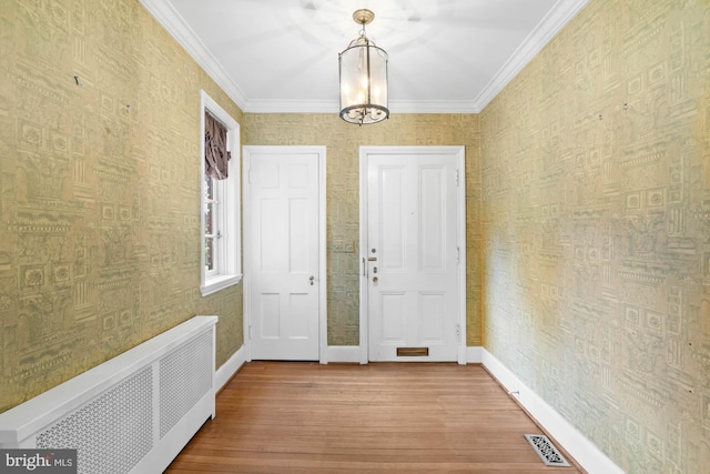 interior space featuring radiator, wallpapered walls, baseboards, and visible vents