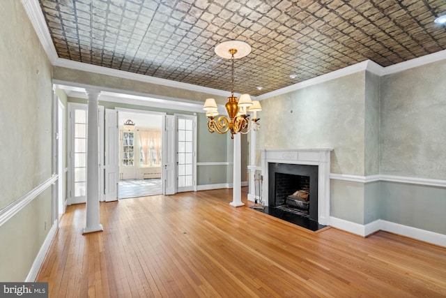 unfurnished living room with ornamental molding, wood-type flooring, an ornate ceiling, and baseboards