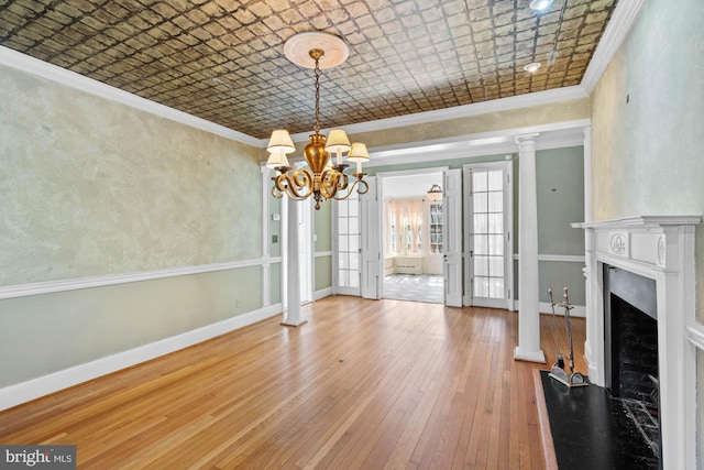 unfurnished dining area featuring ornamental molding, a fireplace, an ornate ceiling, and baseboards