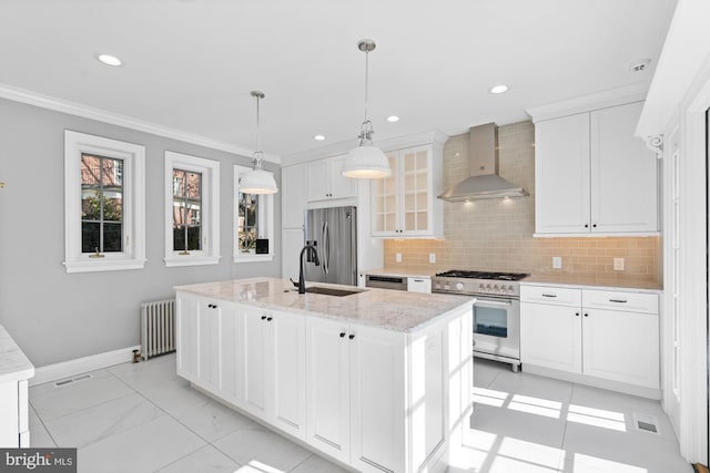 kitchen with radiator, white cabinetry, wall chimney exhaust hood, and appliances with stainless steel finishes