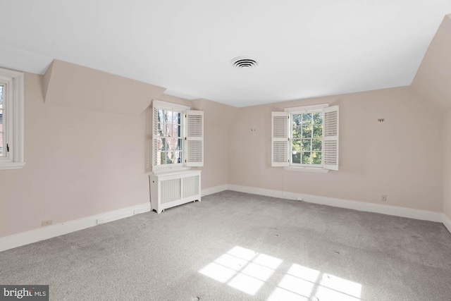 empty room with carpet, radiator, visible vents, and baseboards