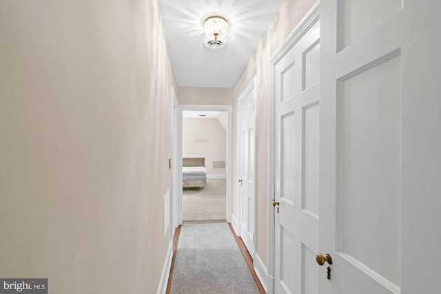 corridor featuring carpet floors, visible vents, and baseboards