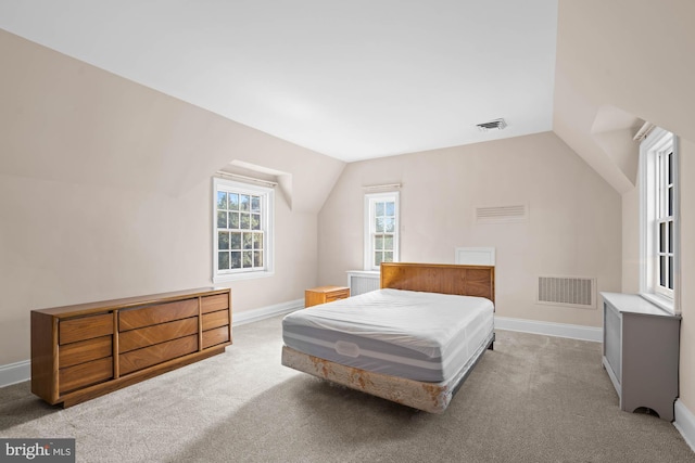 bedroom featuring carpet floors, visible vents, and lofted ceiling