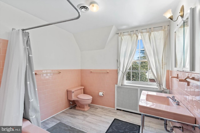 bathroom featuring lofted ceiling, toilet, visible vents, a shower with curtain, and radiator