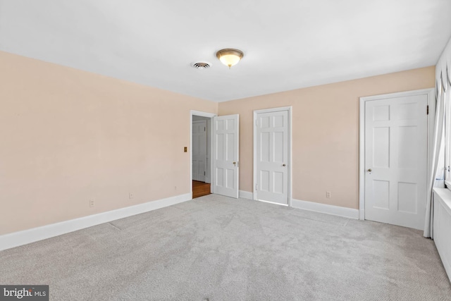 unfurnished bedroom featuring a closet, carpet flooring, visible vents, and baseboards