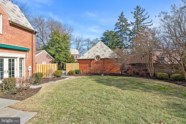 view of yard featuring french doors and fence