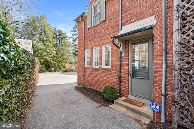 doorway to property featuring brick siding